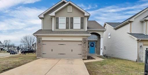 traditional-style home featuring driveway and an attached garage