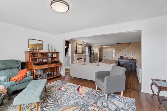 living area featuring arched walkways and wood finished floors