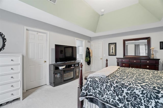 bedroom featuring lofted ceiling, a raised ceiling, visible vents, and light colored carpet