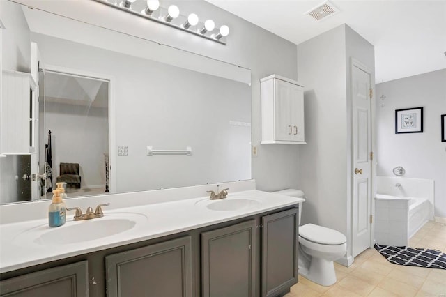 bathroom featuring a garden tub, toilet, a sink, and visible vents