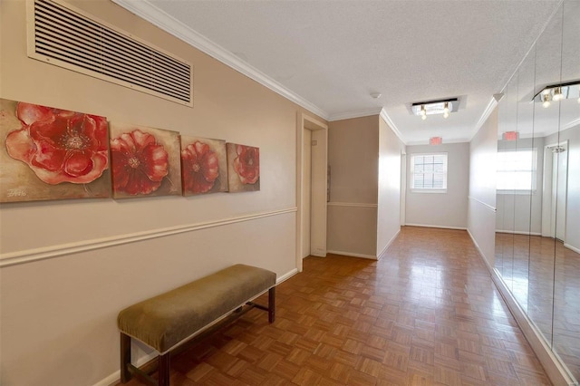 hallway with crown molding, baseboards, visible vents, and a textured ceiling