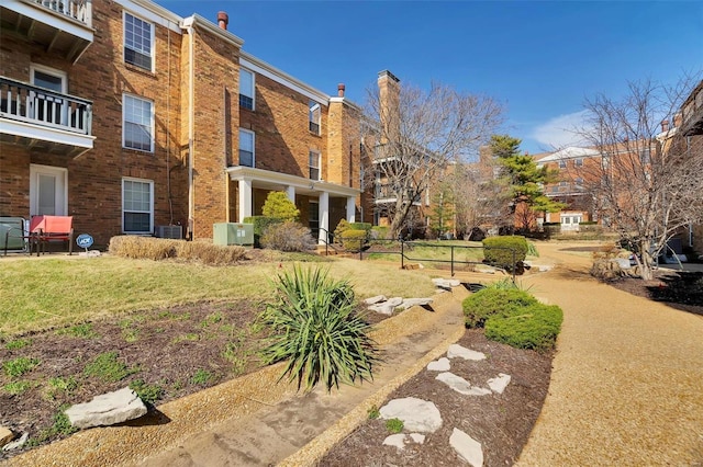 view of home's community with a lawn and fence