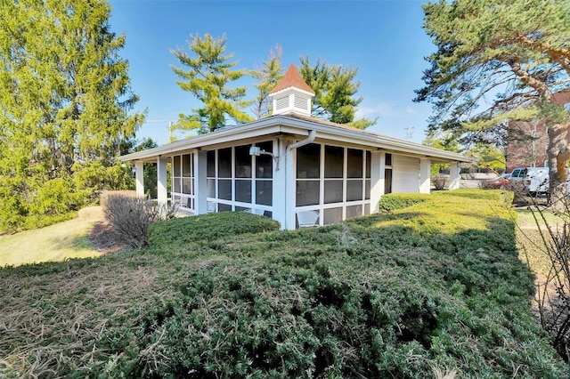 exterior space featuring a lawn and a sunroom