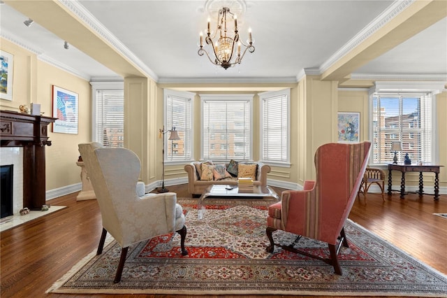 sitting room with a notable chandelier, a fireplace, wood finished floors, and crown molding