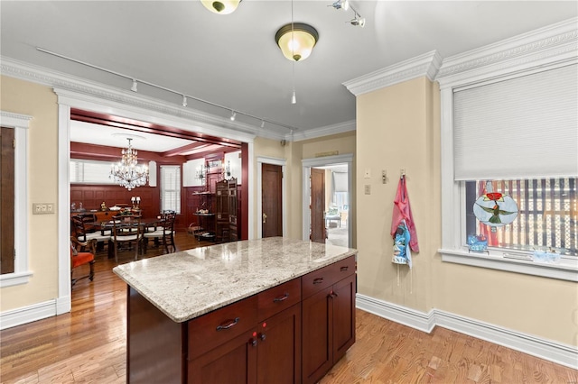 kitchen with light wood-type flooring, baseboards, and ornamental molding