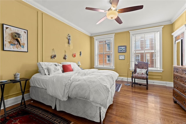 bedroom featuring ornamental molding, a ceiling fan, baseboards, and wood finished floors