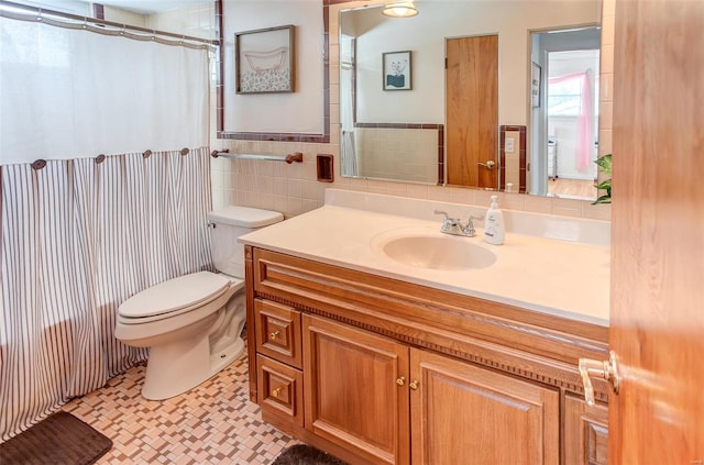 full bathroom with a wainscoted wall, tile walls, toilet, vanity, and a shower with curtain