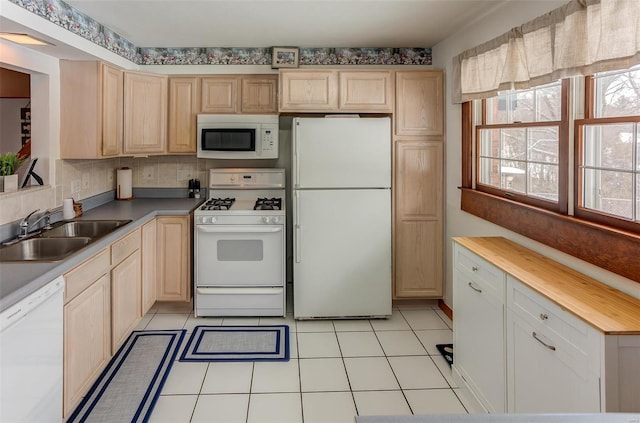 kitchen featuring light tile patterned floors, white appliances, butcher block countertops, a sink, and light brown cabinetry