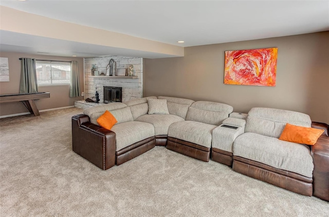 living area featuring light carpet, a stone fireplace, and baseboards