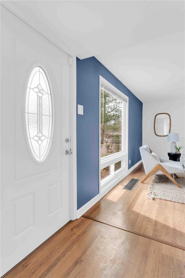 entrance foyer with visible vents, baseboards, and wood finished floors