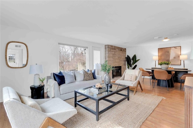 living area with light wood-type flooring and a fireplace