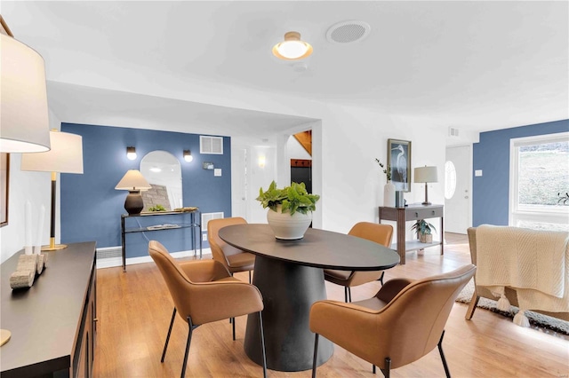 dining area featuring light wood-type flooring, baseboards, and visible vents