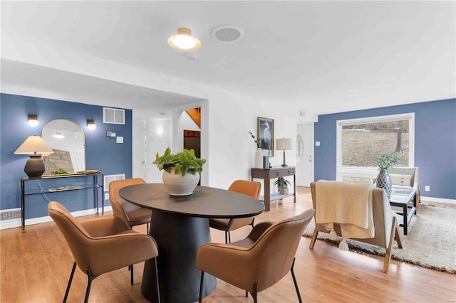 dining area featuring baseboards, visible vents, and light wood-style floors