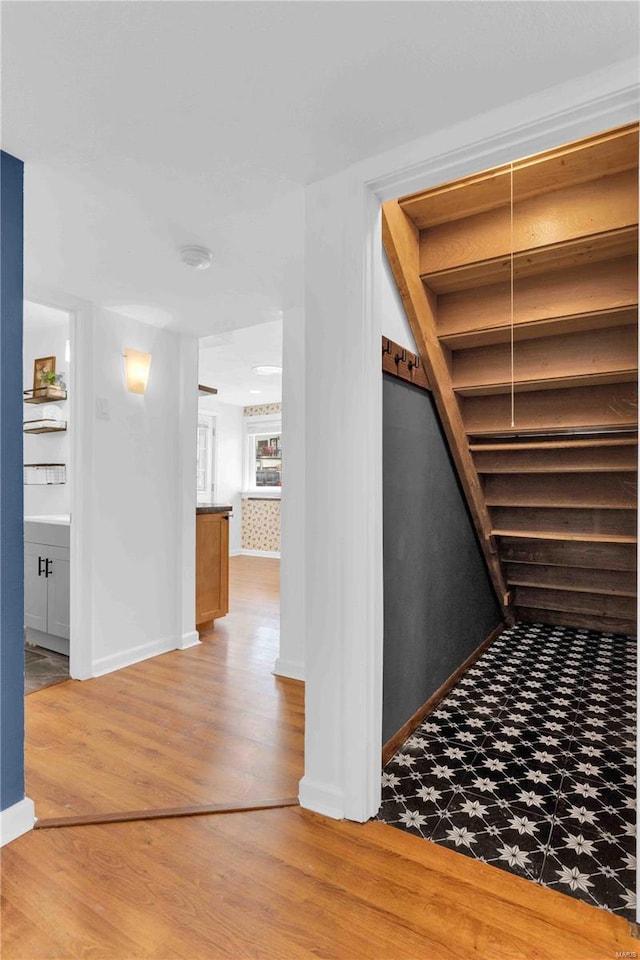 staircase featuring baseboards and wood finished floors