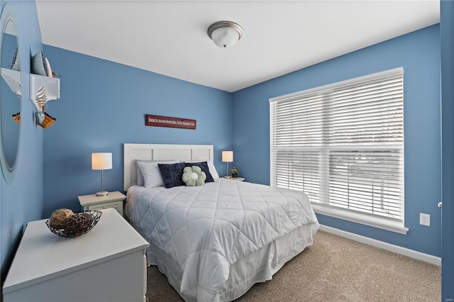 carpeted bedroom featuring multiple windows and baseboards