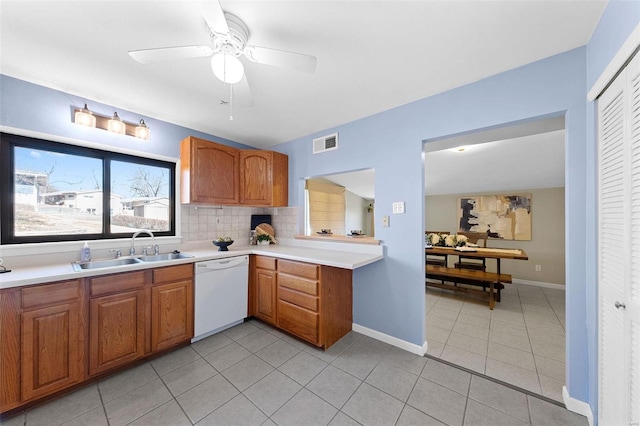 kitchen with light countertops, visible vents, dishwasher, and a sink