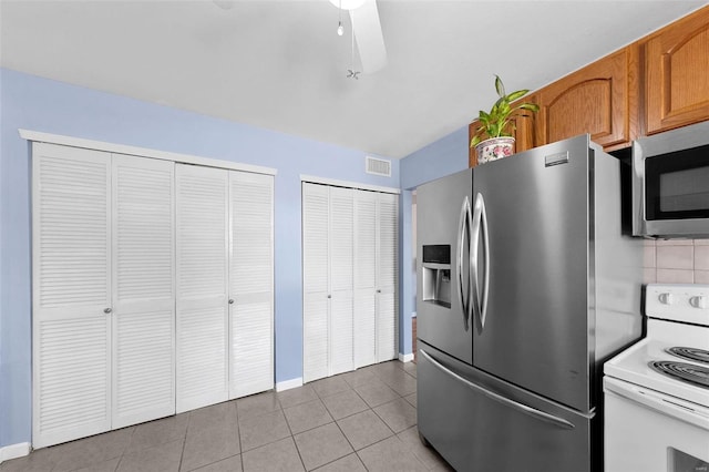 kitchen featuring visible vents, appliances with stainless steel finishes, brown cabinetry, tile patterned flooring, and baseboards