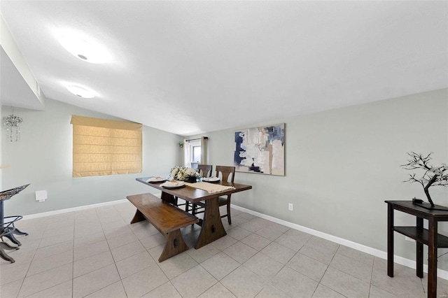 dining room featuring vaulted ceiling, baseboards, and light tile patterned floors