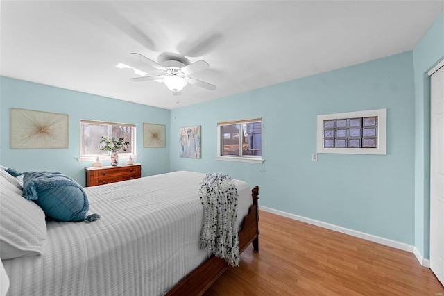 bedroom featuring a ceiling fan, baseboards, and wood finished floors