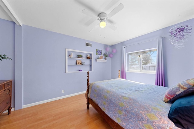 bedroom with baseboards, visible vents, ceiling fan, and wood finished floors