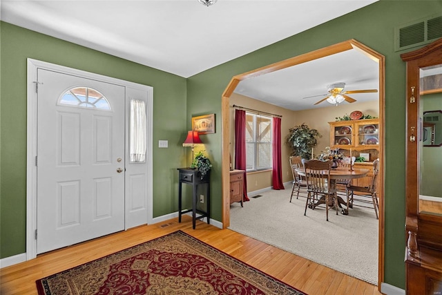 entrance foyer featuring a ceiling fan, baseboards, visible vents, and wood finished floors