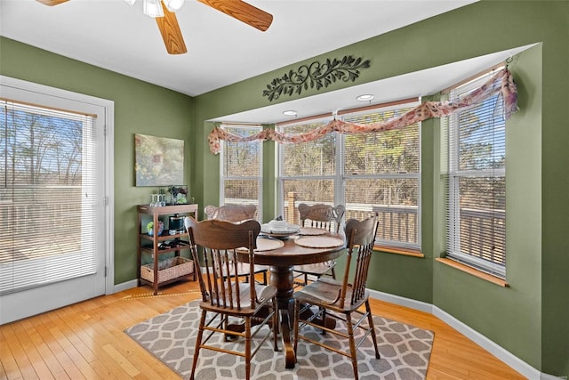 dining space featuring light wood-type flooring, a wealth of natural light, and baseboards