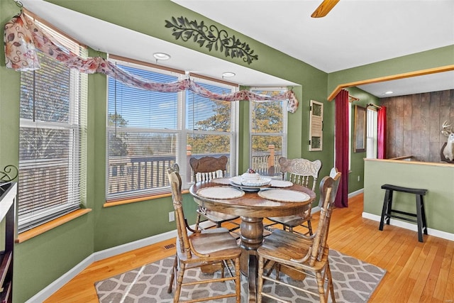 dining space with ceiling fan, baseboards, and wood finished floors