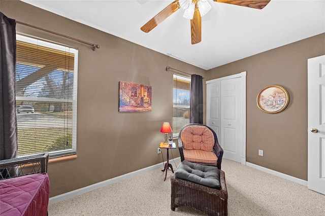 living area with carpet floors, ceiling fan, and baseboards