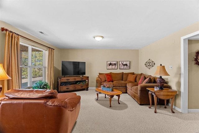 living area with baseboards, visible vents, and carpet flooring