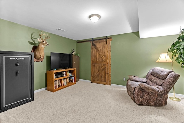 sitting room with a barn door, visible vents, baseboards, and carpet flooring