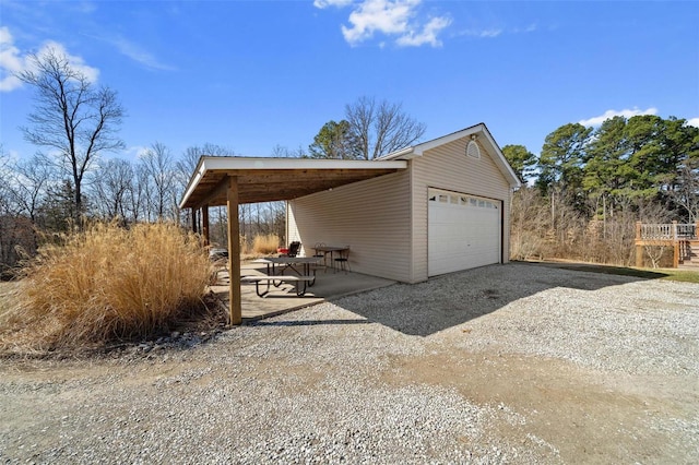 garage with driveway and a detached garage