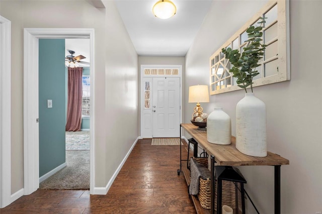 interior space with ceiling fan, baseboards, and dark wood finished floors