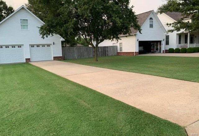 yard at dusk featuring a garage and fence