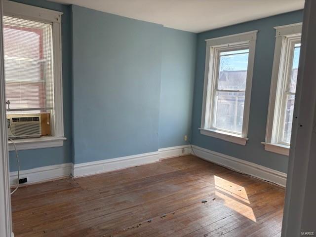 spare room with hardwood / wood-style flooring, baseboards, and cooling unit