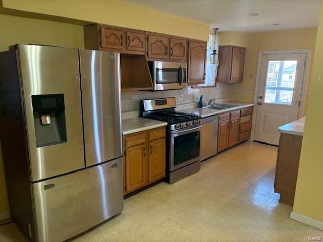 kitchen with stainless steel appliances, brown cabinets, light countertops, and light floors