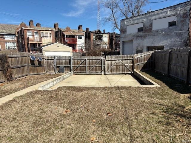 view of yard with a fenced backyard and a gate