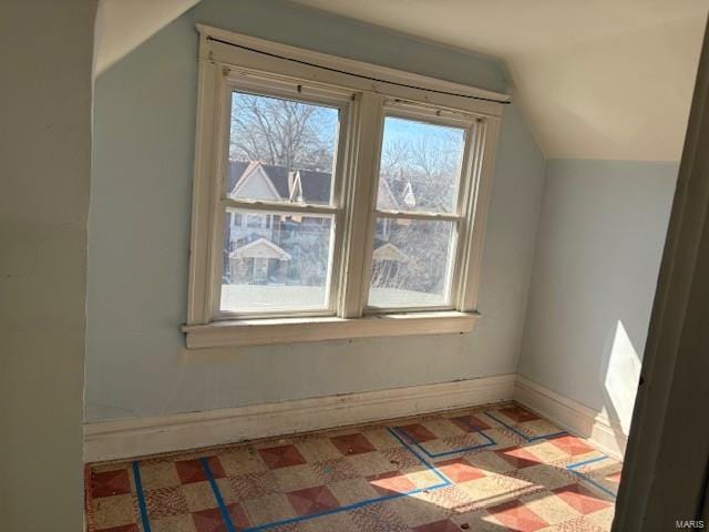 bonus room featuring vaulted ceiling, light floors, and baseboards