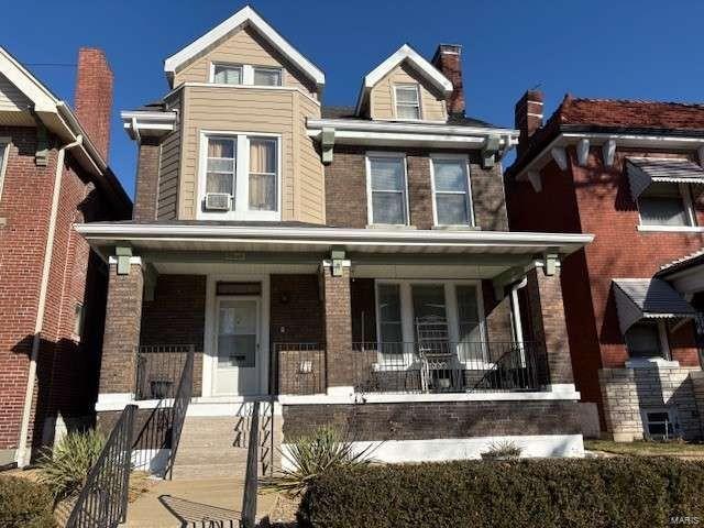 view of front of house featuring a porch and brick siding