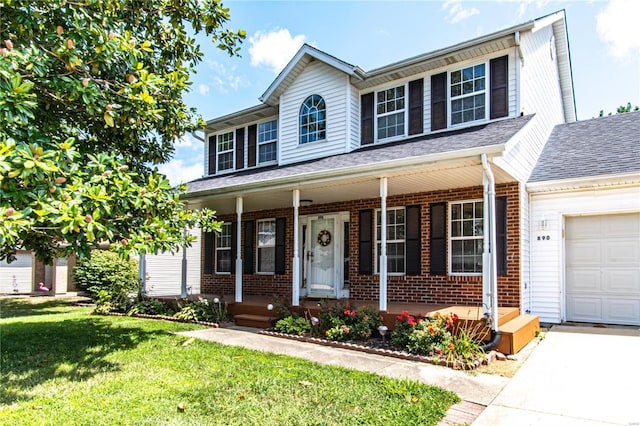 traditional-style home featuring an attached garage, covered porch, brick siding, roof with shingles, and a front yard