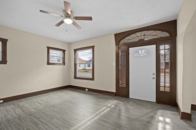 foyer featuring dark wood-style flooring, ceiling fan, a textured ceiling, and baseboards