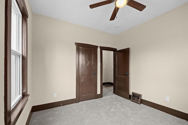 unfurnished bedroom featuring light carpet, ceiling fan, and baseboards