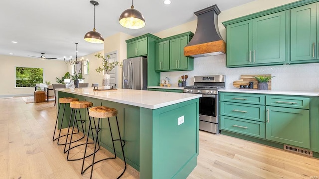 kitchen featuring appliances with stainless steel finishes, light countertops, a center island, and custom range hood