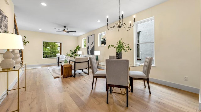 dining area featuring baseboards, light wood finished floors, ceiling fan with notable chandelier, and recessed lighting