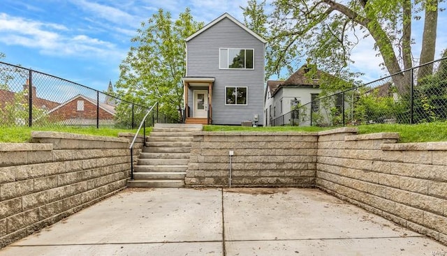 view of front of house with a patio area and fence