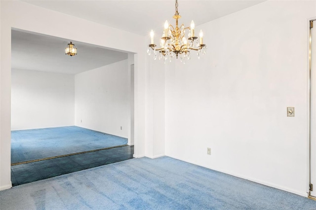 carpeted empty room with a notable chandelier