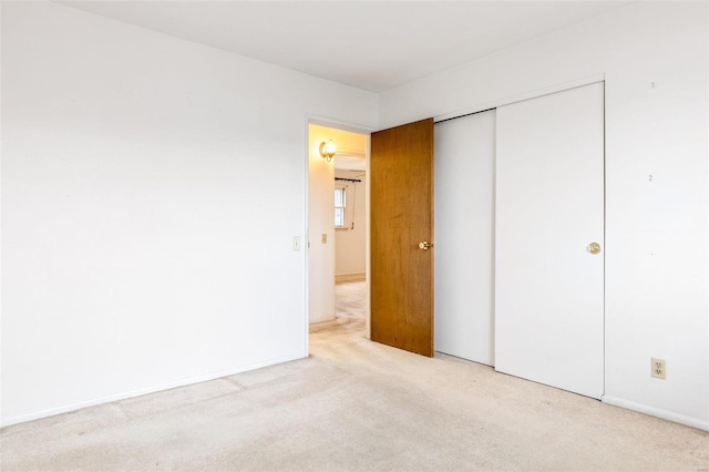 unfurnished bedroom with a closet, baseboards, and carpet flooring