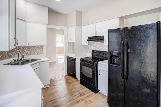 kitchen with black appliances, under cabinet range hood, a sink, white cabinets, and light countertops