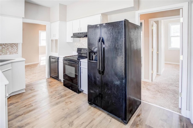 kitchen featuring decorative backsplash, black appliances, white cabinets, and under cabinet range hood