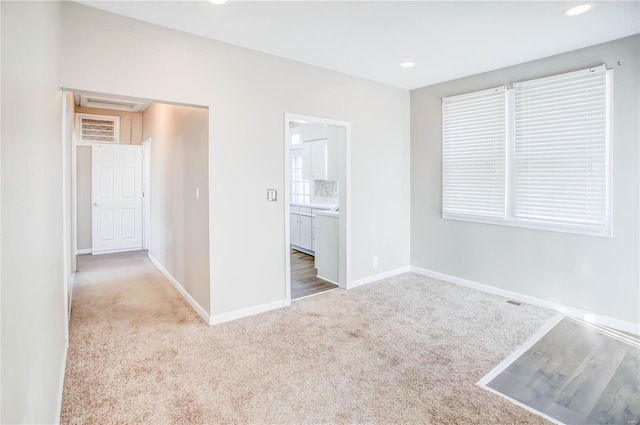 unfurnished bedroom with recessed lighting, carpet, baseboards, and connected bathroom