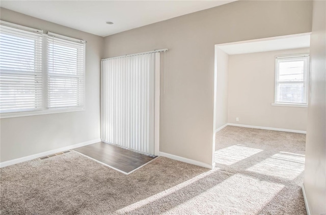 spare room with visible vents, baseboards, and carpet